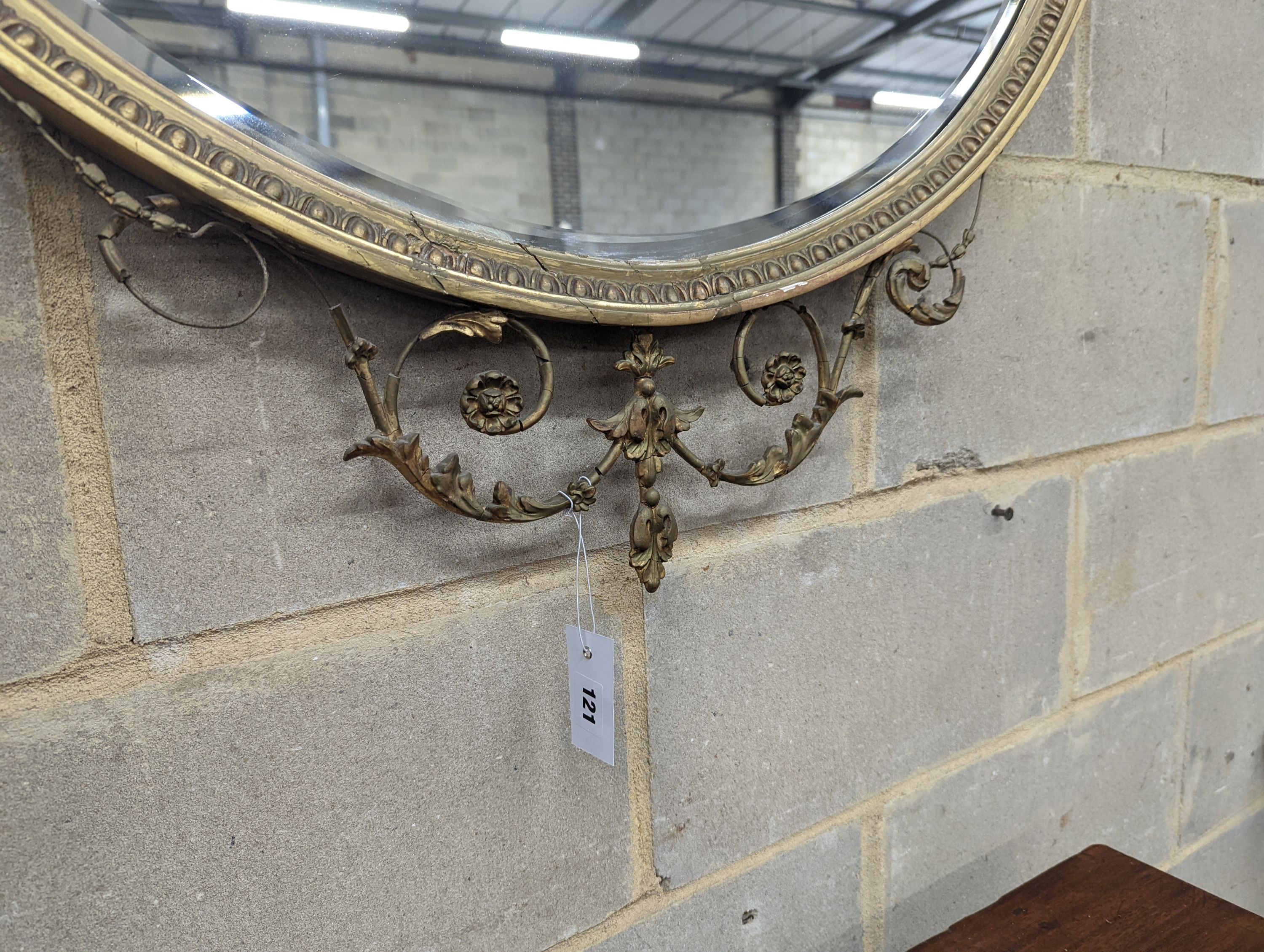 An Edwardian Adam design giltwood and gesso shield shaped wall mirror, width 92cm, height 94cm